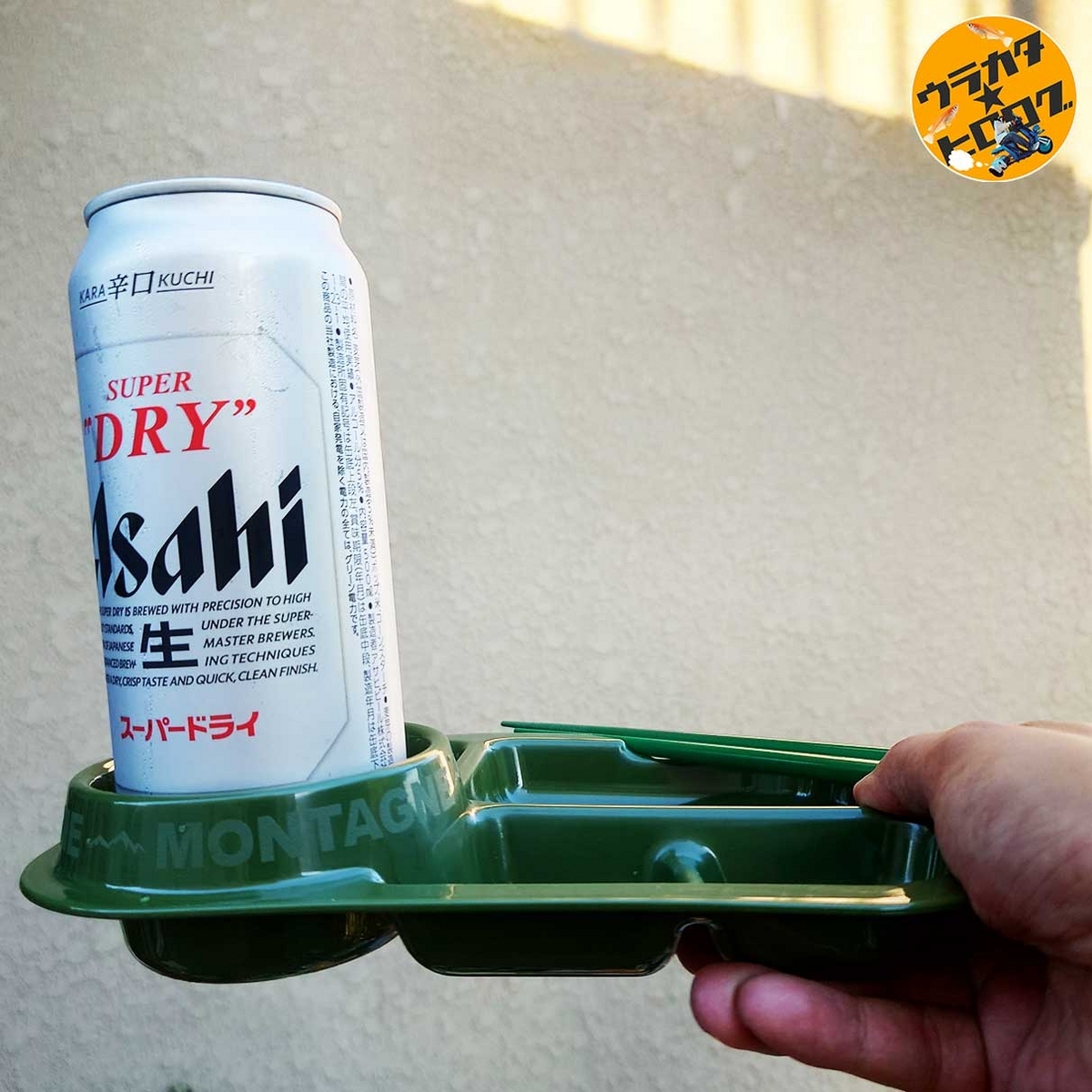 100円ショップセリアのスクエアトレイのカップホルダーに500mlのアサヒスーパードライを置き、片手持ちをして耐久度を確かめている様子