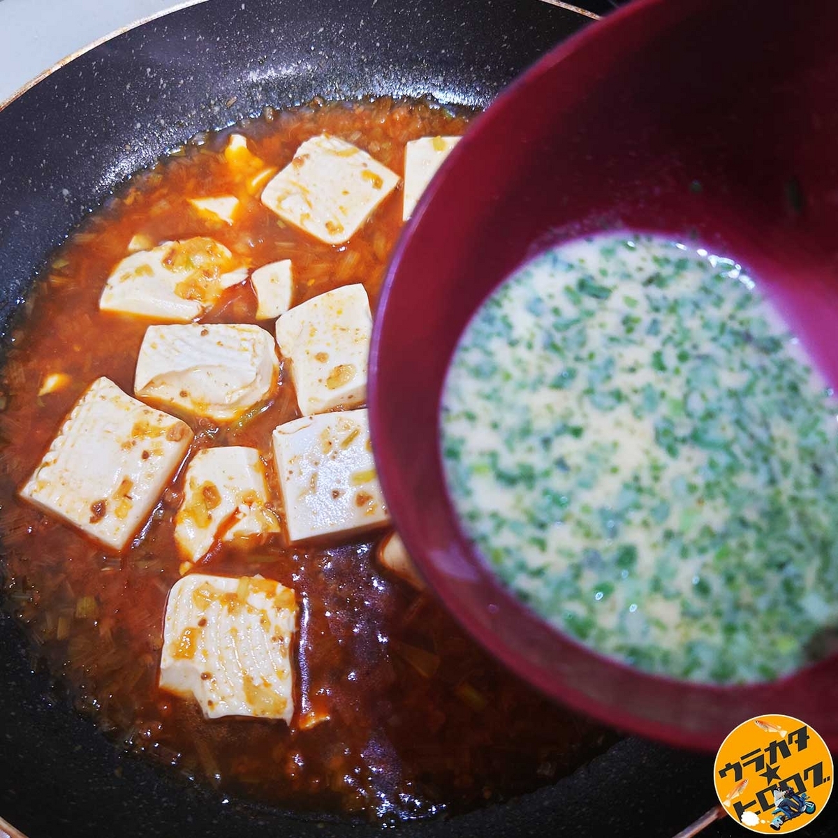 火をとめた麻婆豆腐に水で溶いたとろみ粉を回しいれている様子(筆者撮影+調理)