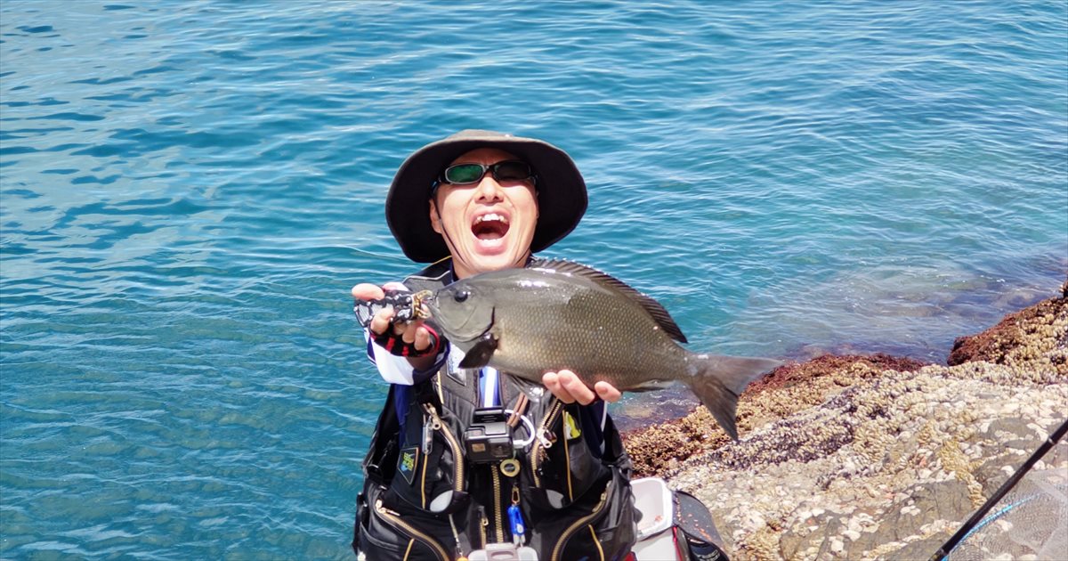 尾長グレを持つ釣り人