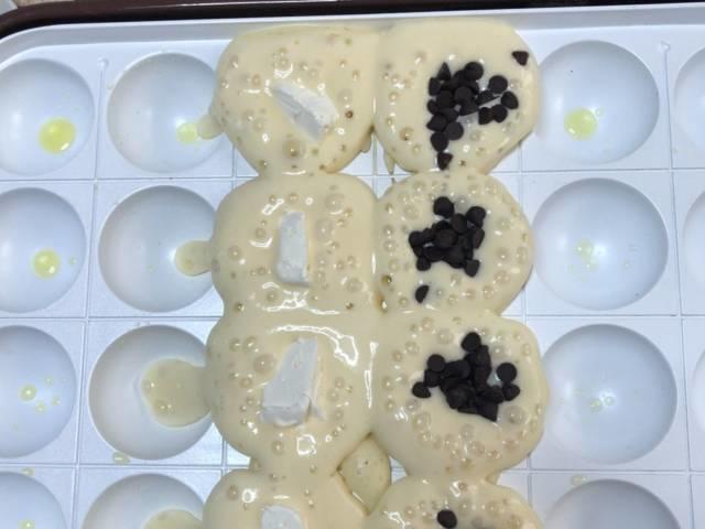 写真:たこ焼きホットケーキの具材を入れる