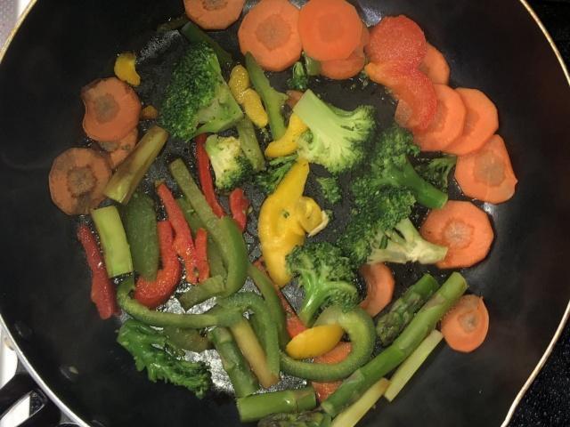 写真:フライパンで野菜を焼く