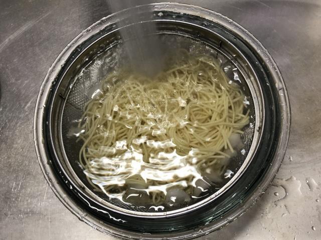 写真:茹でた麺を冷水で洗う