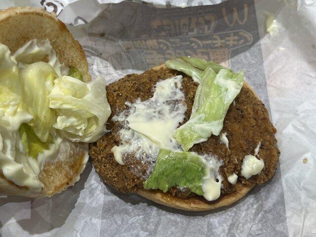 写真:「名古屋名物手羽先風黒胡椒ジューシーチキン」バンズの下