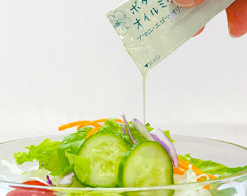 持ち運び用の美容ボタニカルオイルをサラダにかけている写真