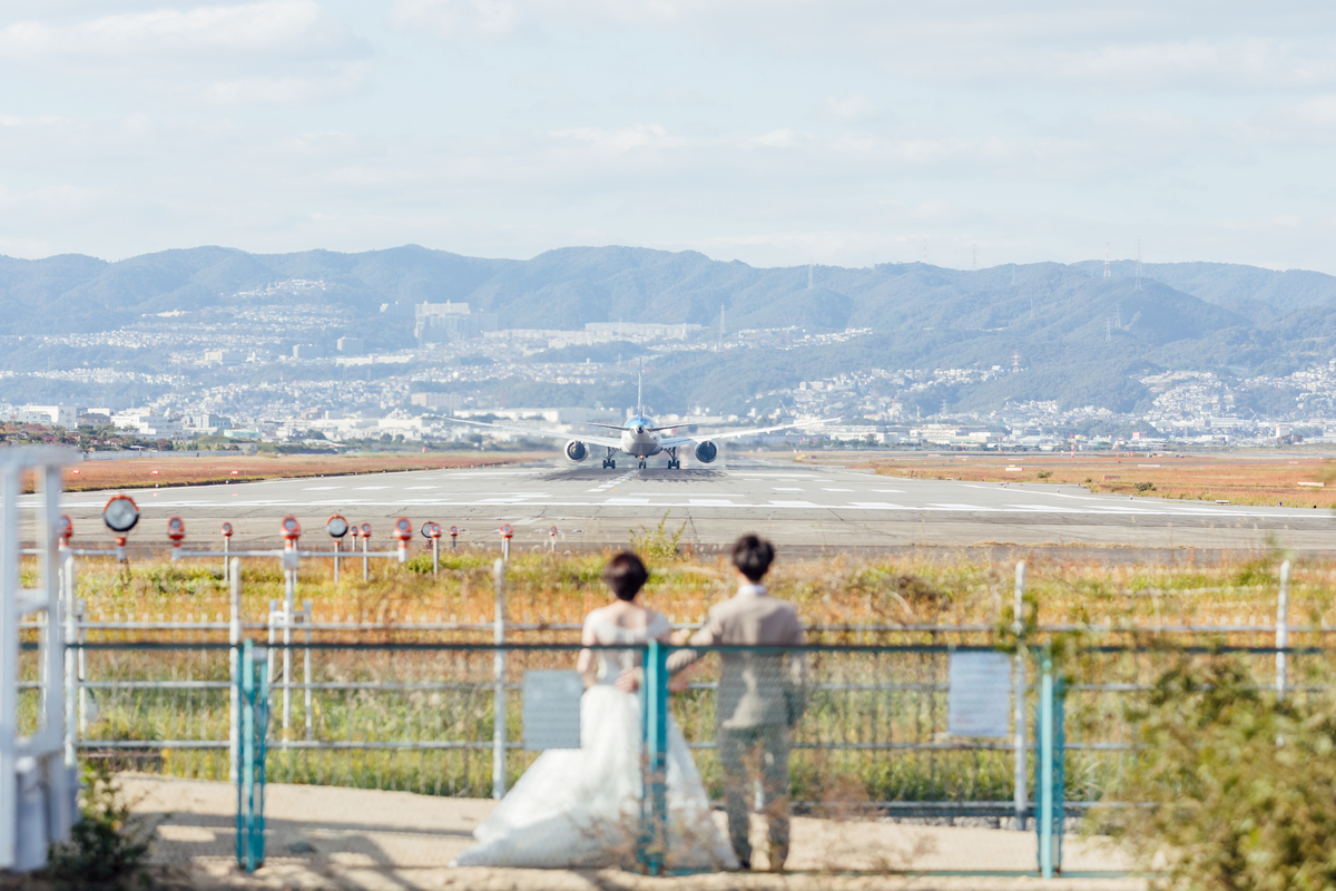 千里側土手から夫婦と離陸機を望遠で抜いた写真