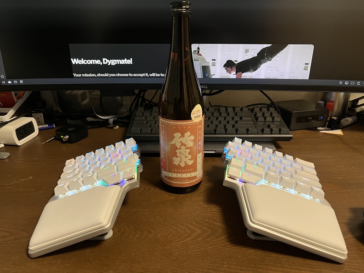 Dygma Raise 2とその間に置かれた日本酒の瓶の写真