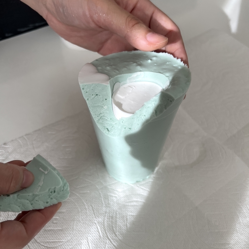 石膏でできた2歳児の手型を慎重に取り出し始めたところ。