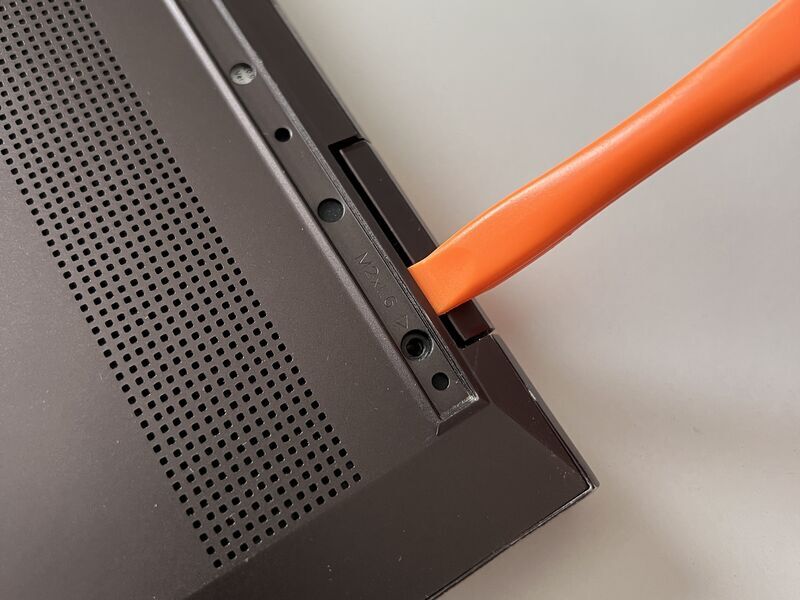 HP ENVY x360 13-ag0010AUの背面カバーをヘラで外している様子