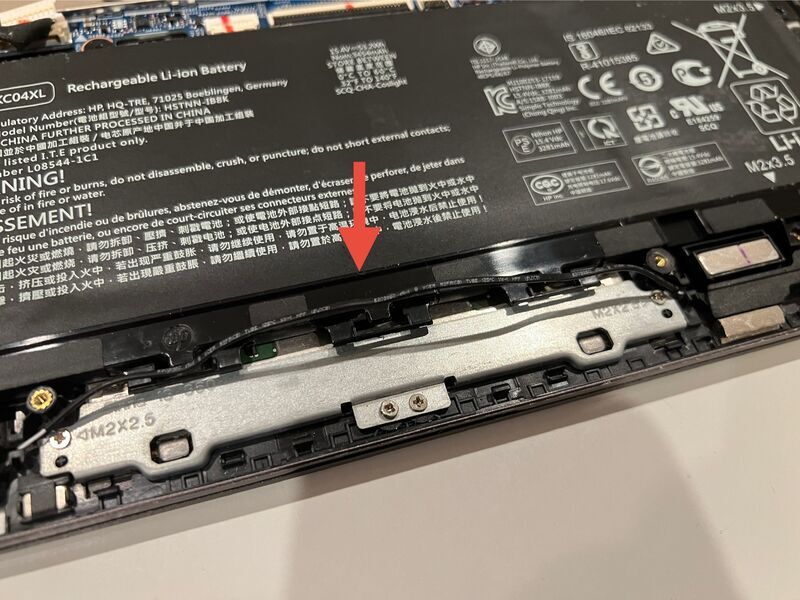 ノートパソコン内部のバッテリー配線を固定している留め具から外している様子