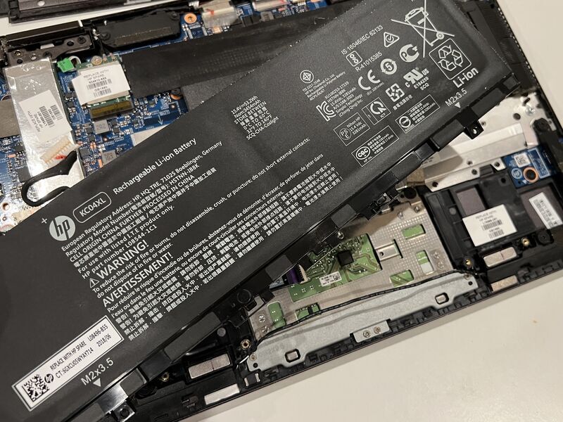 ノートPCからバッテリー本体を持ち上げて取り外している様子