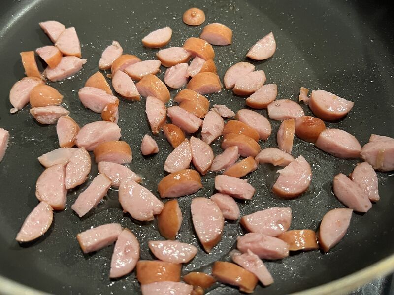 半月切りにしたウインナーをフライパンで焼いているところ