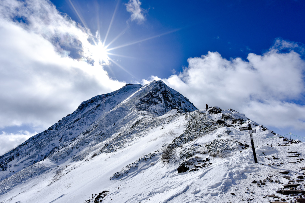 冬の赤岳山頂を照らす太陽のフリー画像（写真）