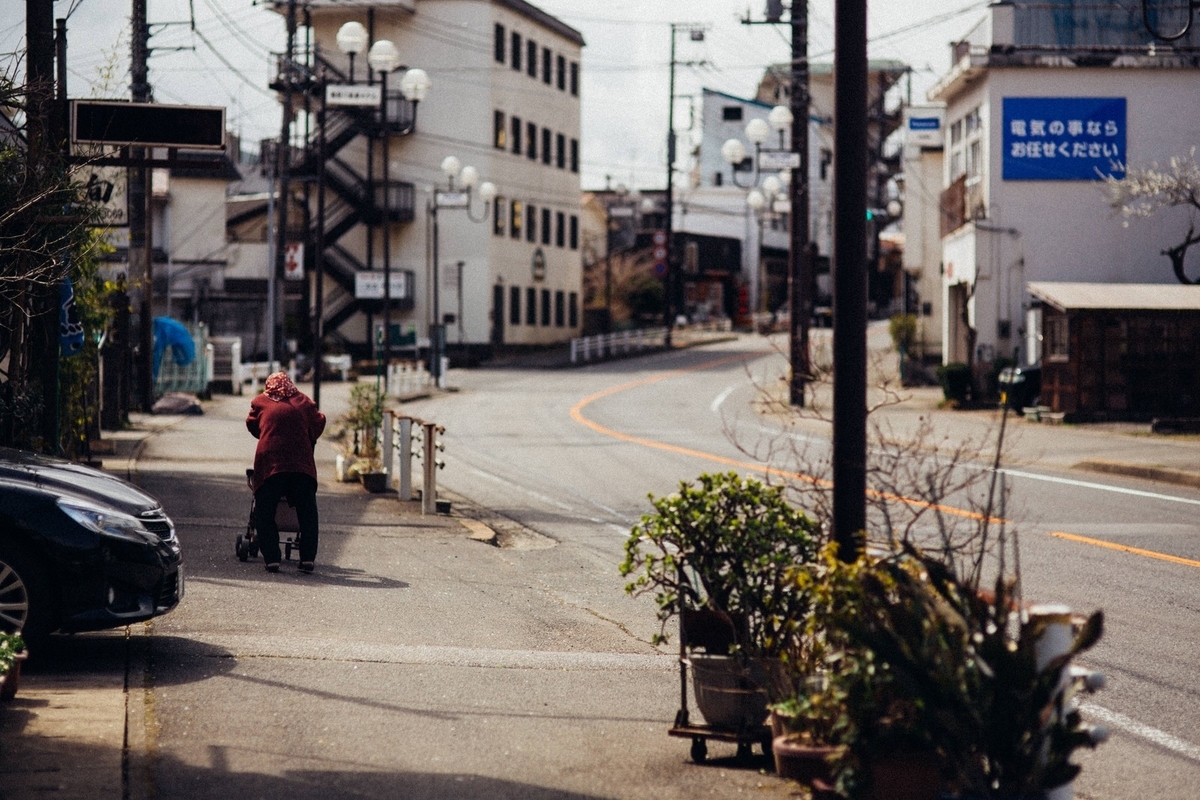 閑散とした街と老婆の後ろ姿のフリー画像（写真）