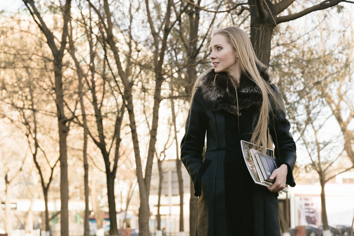 公園で雑誌を持ったブロンド美女のフリー画像（写真）