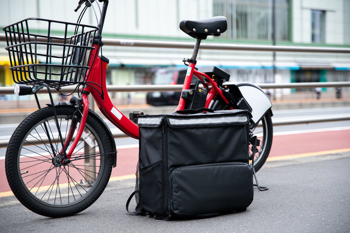 フードデリバリー用のバッグとシェアサイクルの写真素材