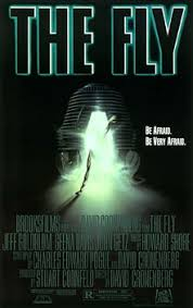 "映画『ザ・フライ』（1986年）の公式ポスター。黒い背景の上部に緑色に光るタイトル『THE FLY』が大きく表示され、中央には暗い中に黒いまゆのような転送ポッドの入り口から光があふれ、そこから巨大な昆虫の脚のようなものが伸びている。中央右に『Be Afraid. Be Very Afraid.』のキャッチコピー、下部にデヴィッド・クローネンバーグ監督、主演ジェフ・ゴールドブラム、ジーナ・デイヴィスらのクレジットが記載されたホラーSFのクラシックポスター。"