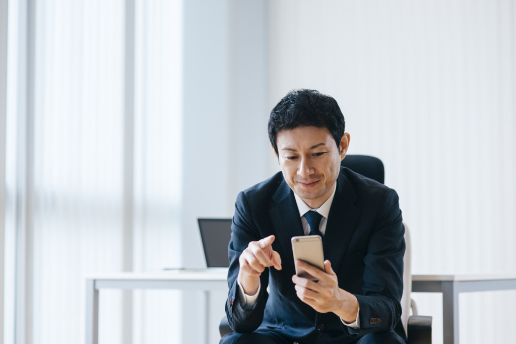 携帯をいじる男性