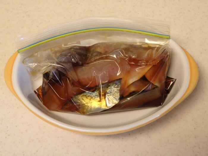 アジとつけ汁を入れた袋をお皿の上に置いた写真