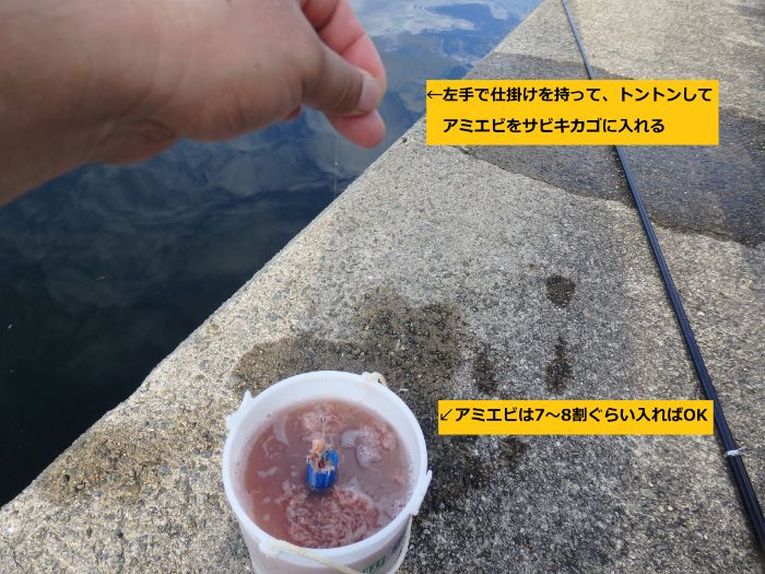 すいこみバケツでサビキカゴにアミエビを入れている写真