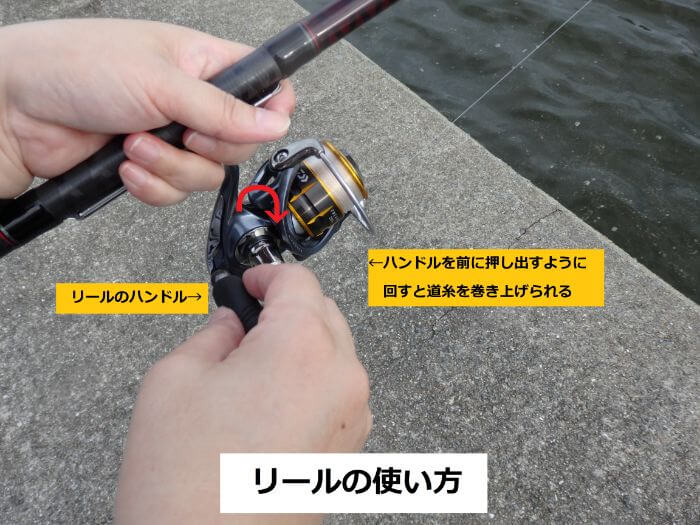リールのハンドルを回して道糸を巻き上げている写真