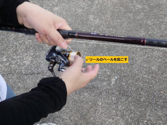 仕掛けを落とすためにリールのベールを起こしている写真