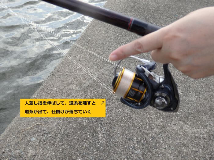 道糸を引っ掛けていた人差し指を離し道糸が出ていっている写真