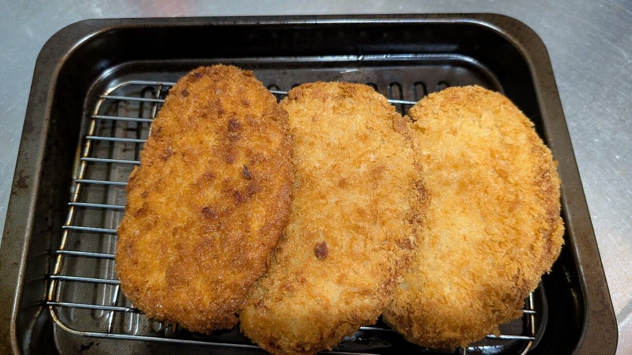 冷凍豚ロースカツを小さな揚げ鍋で1枚ずつ揚げている様子