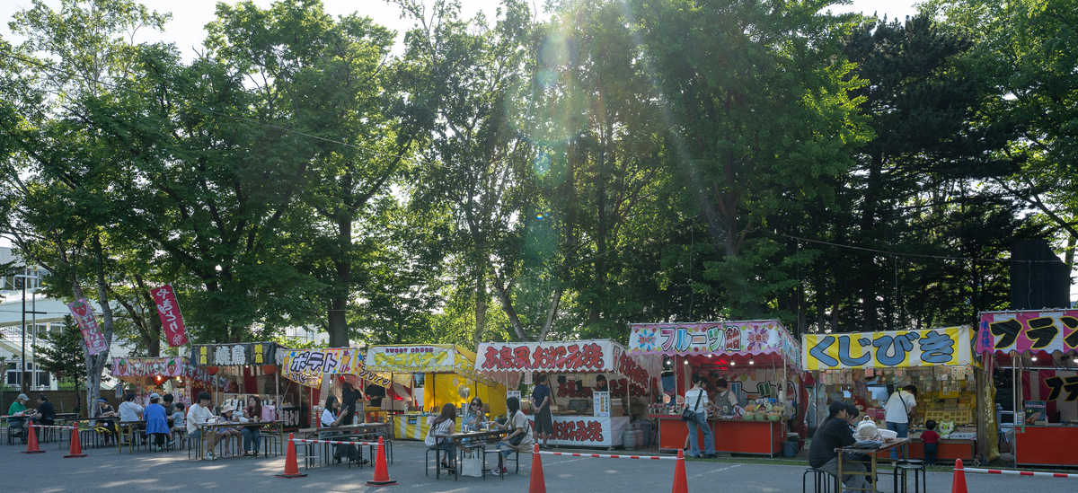 新琴似神社の境内に並ぶ夏祭りの屋台と人々