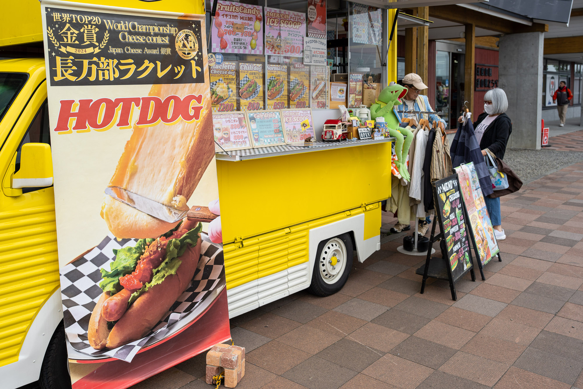 黄色いキッチンカー「長万部ラケット」とホットドッグの看板