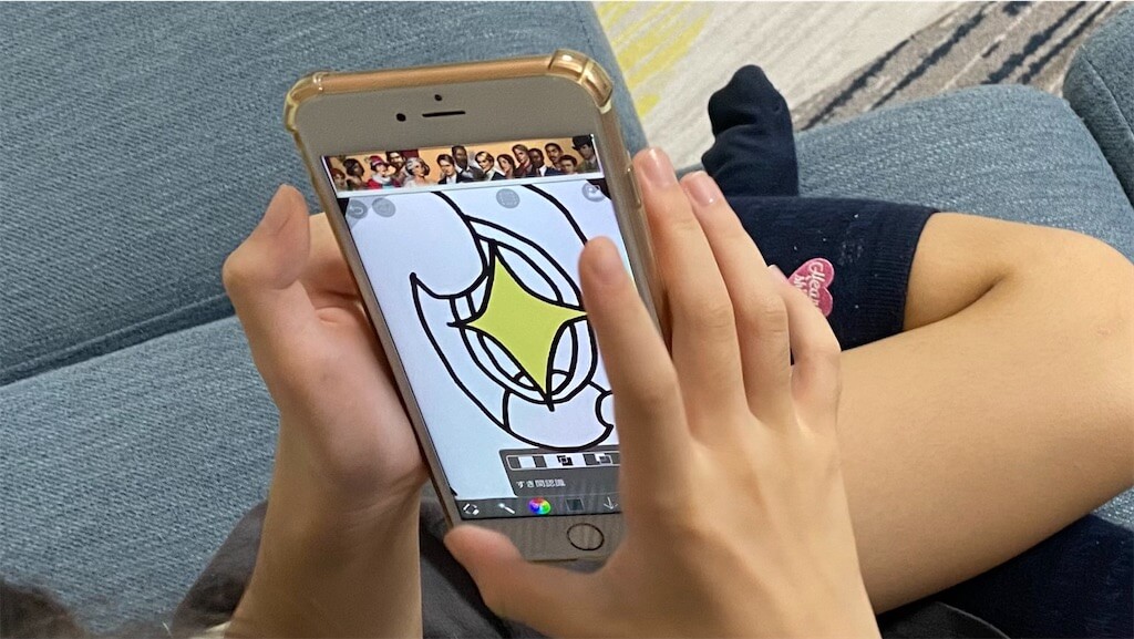 iPhoneでお絵描きする娘