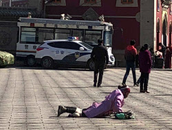 「五体投地」で巡礼するチベット族を監視する警察車両（２月、青海省西寧）