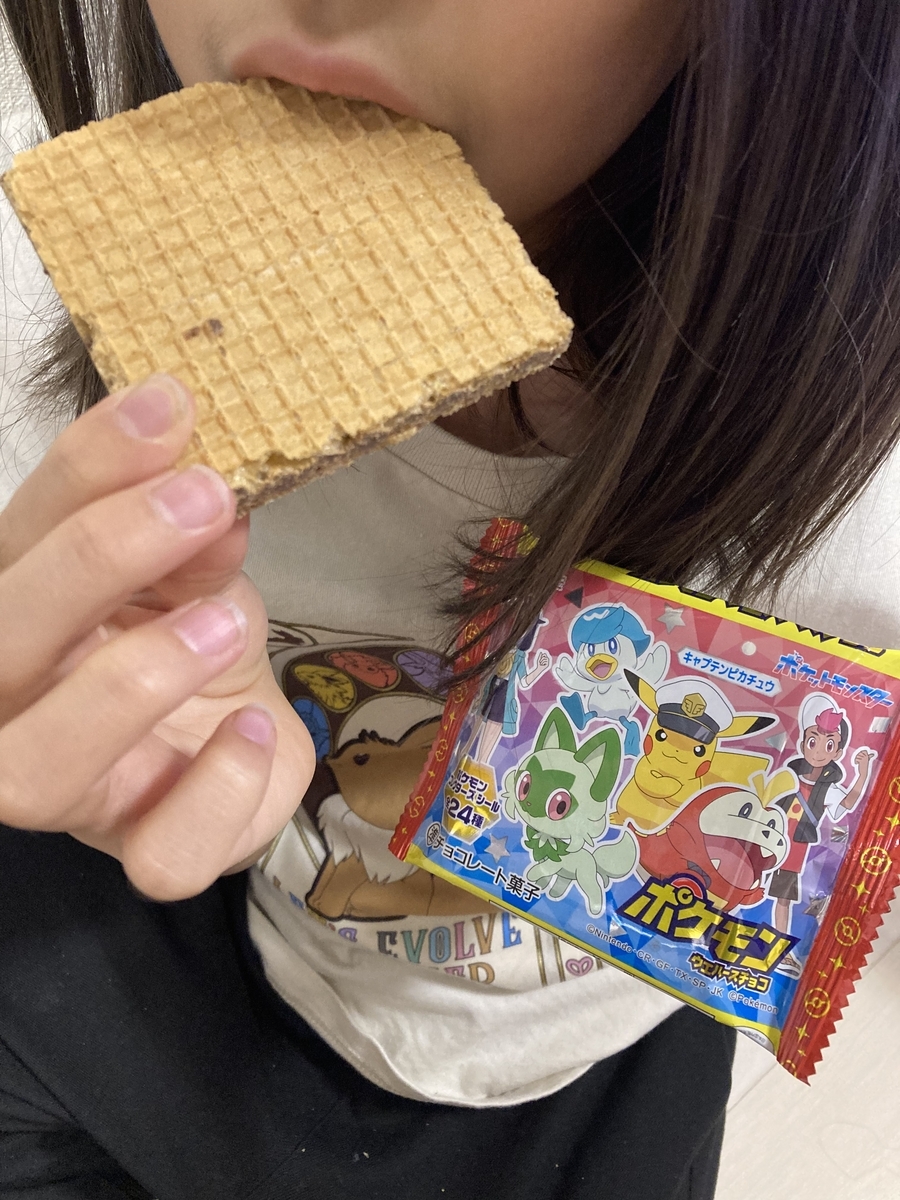 小学生女子がポケモンウエハースを食べている