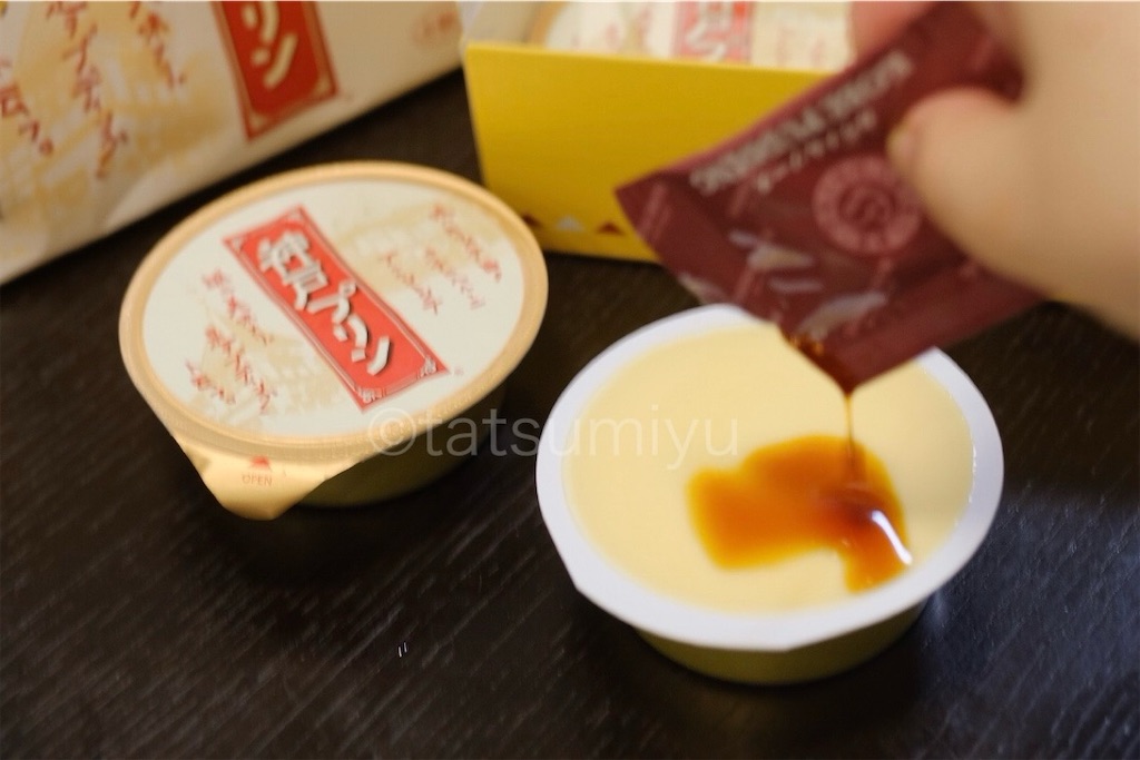 神戸プリンにカラメルソースをかけている