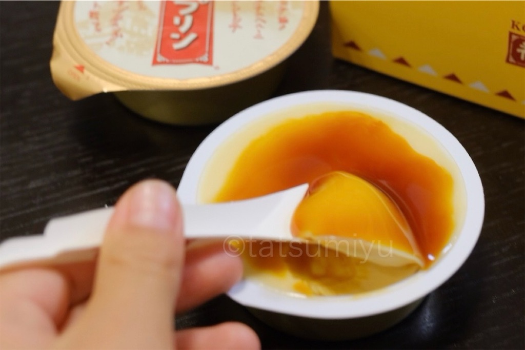 神戸プリンを付属の紙スプーンですくって食べようとしている
