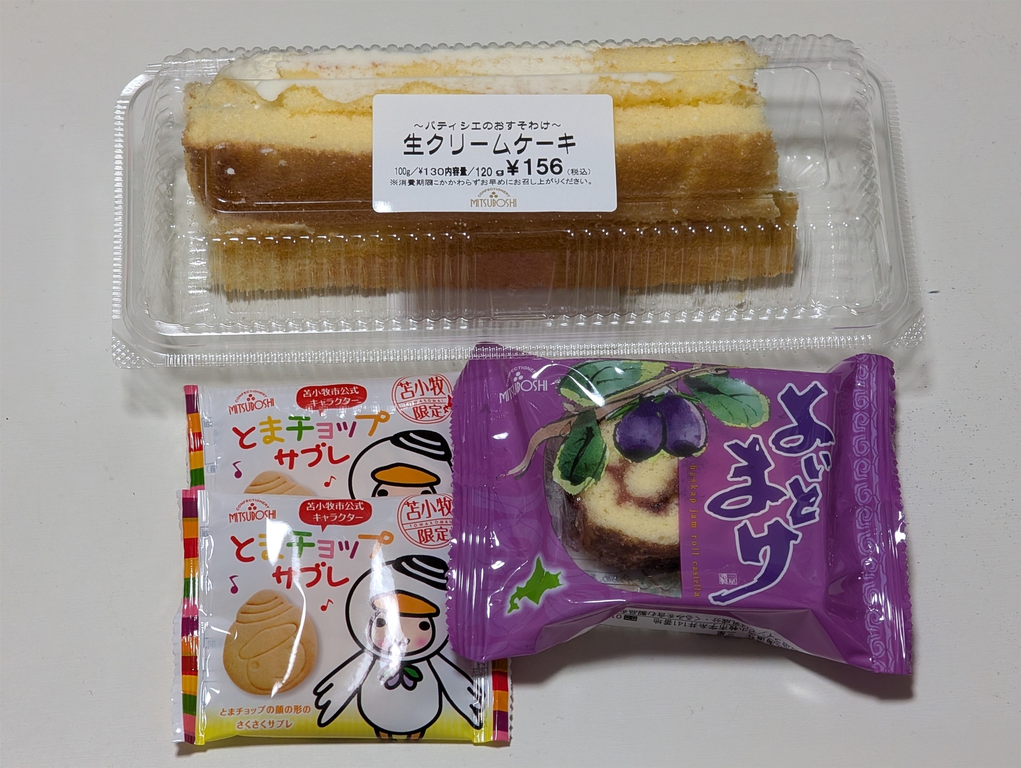 購入してきたもの。ケーキの端切れ、とまチョップサブレのバラ売り2個、よいとまけ1切れ個包装。